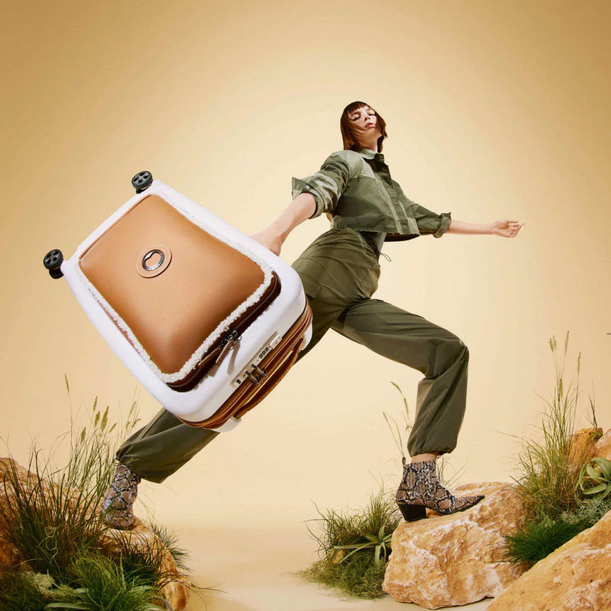 woman holding brown delsey luggage