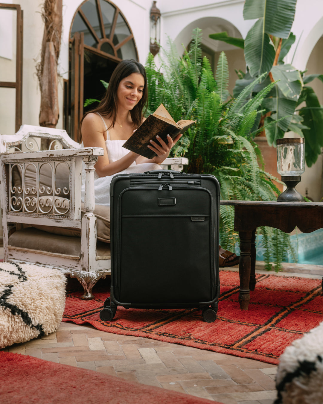 Woman sitting in Mexico hotel with briggs and riley luggage