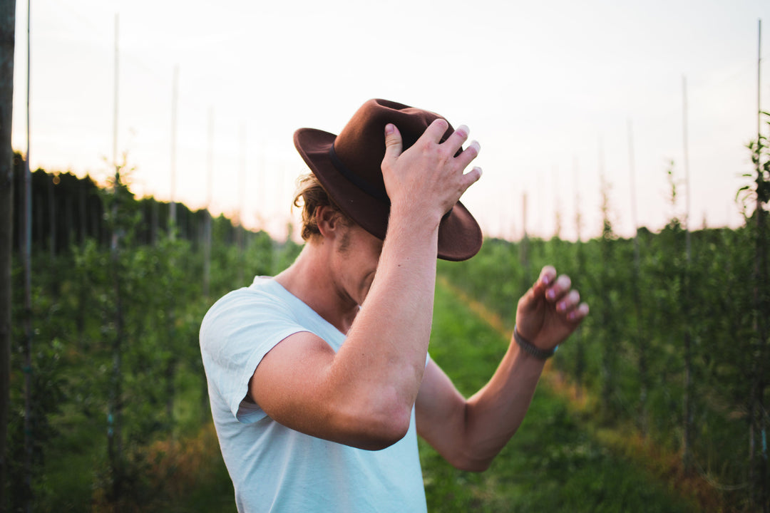 Man wearing hat in tree farm