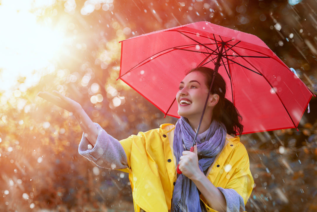 woman wearing yellow mycra pac raincoat with red umbrella