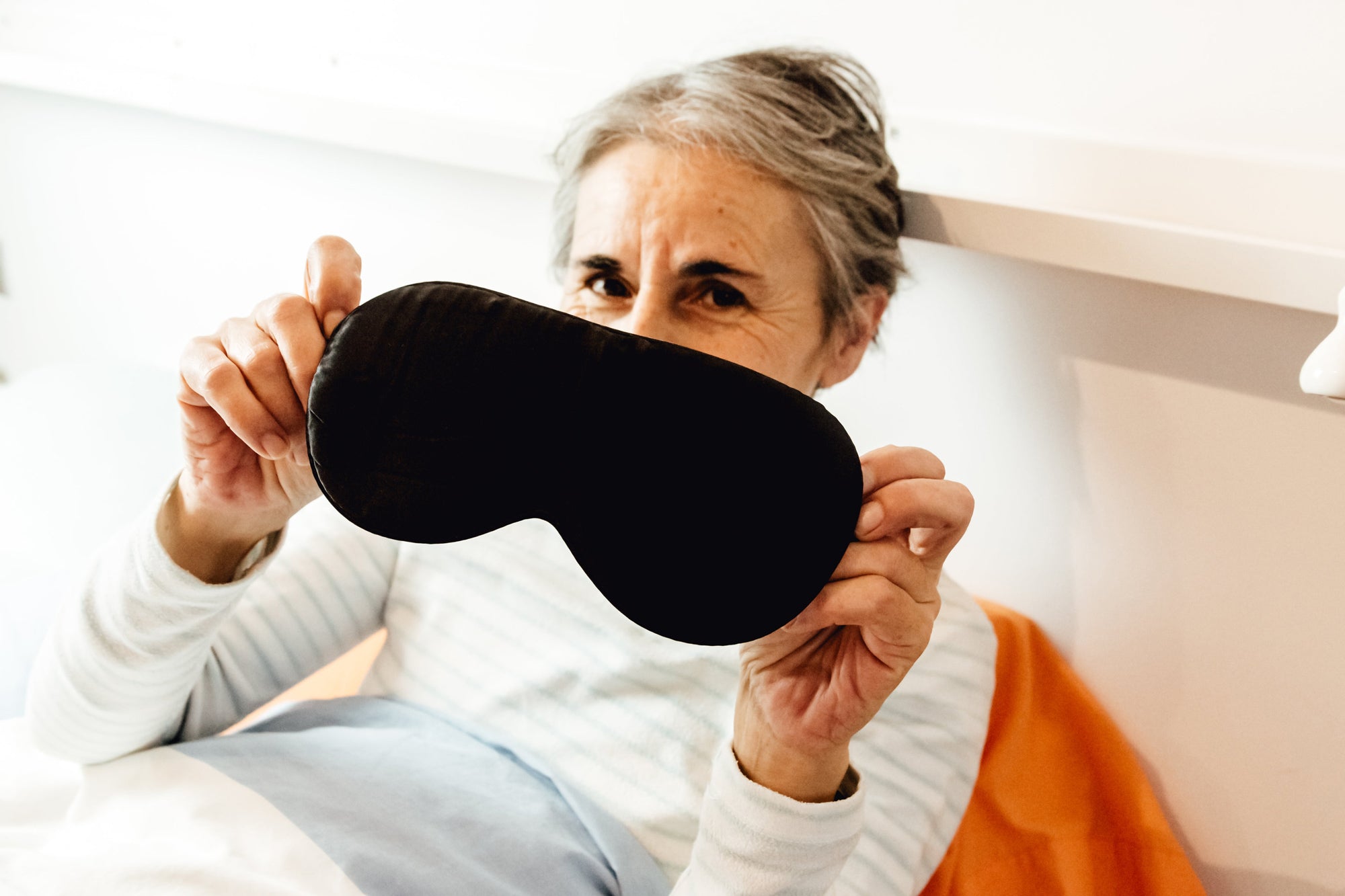 woman holds eye mask