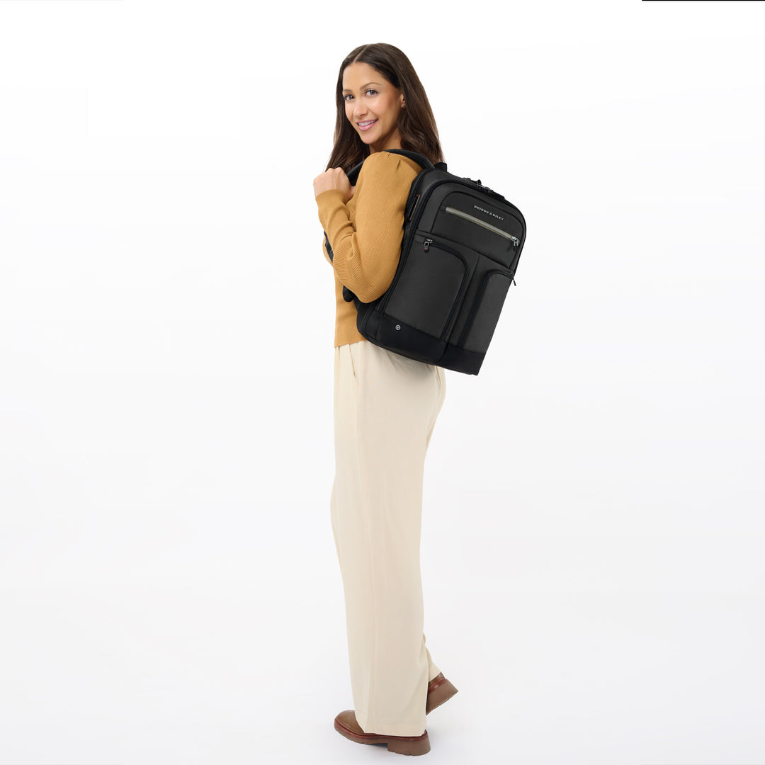 Woman models black briggs and riley slim expandable backpack