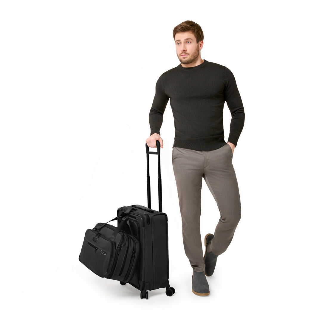 Man Models Briggs & Riley Baseline Essential 22" Carry On Expandable Spinner with additional strap to strap laptop bag