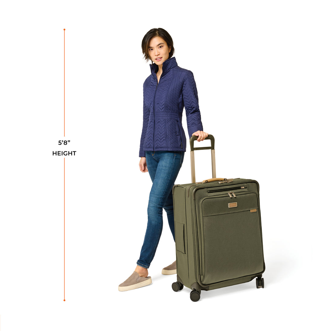 5'8" female model demonstrates Medium Expandable suitcase in color Olive green