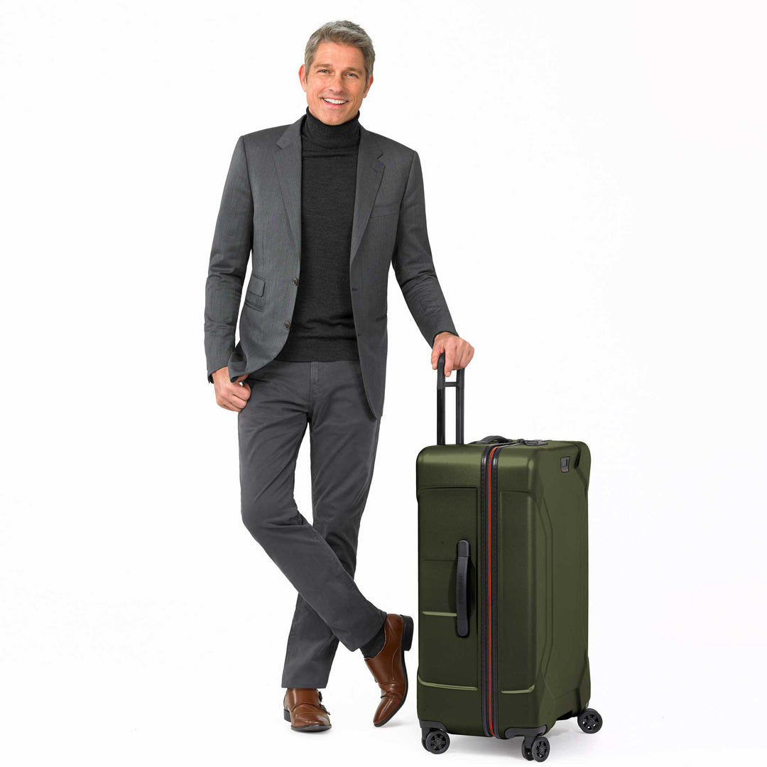 Male model in suit with briggs and riley Large Spinner hardside suitcase in green