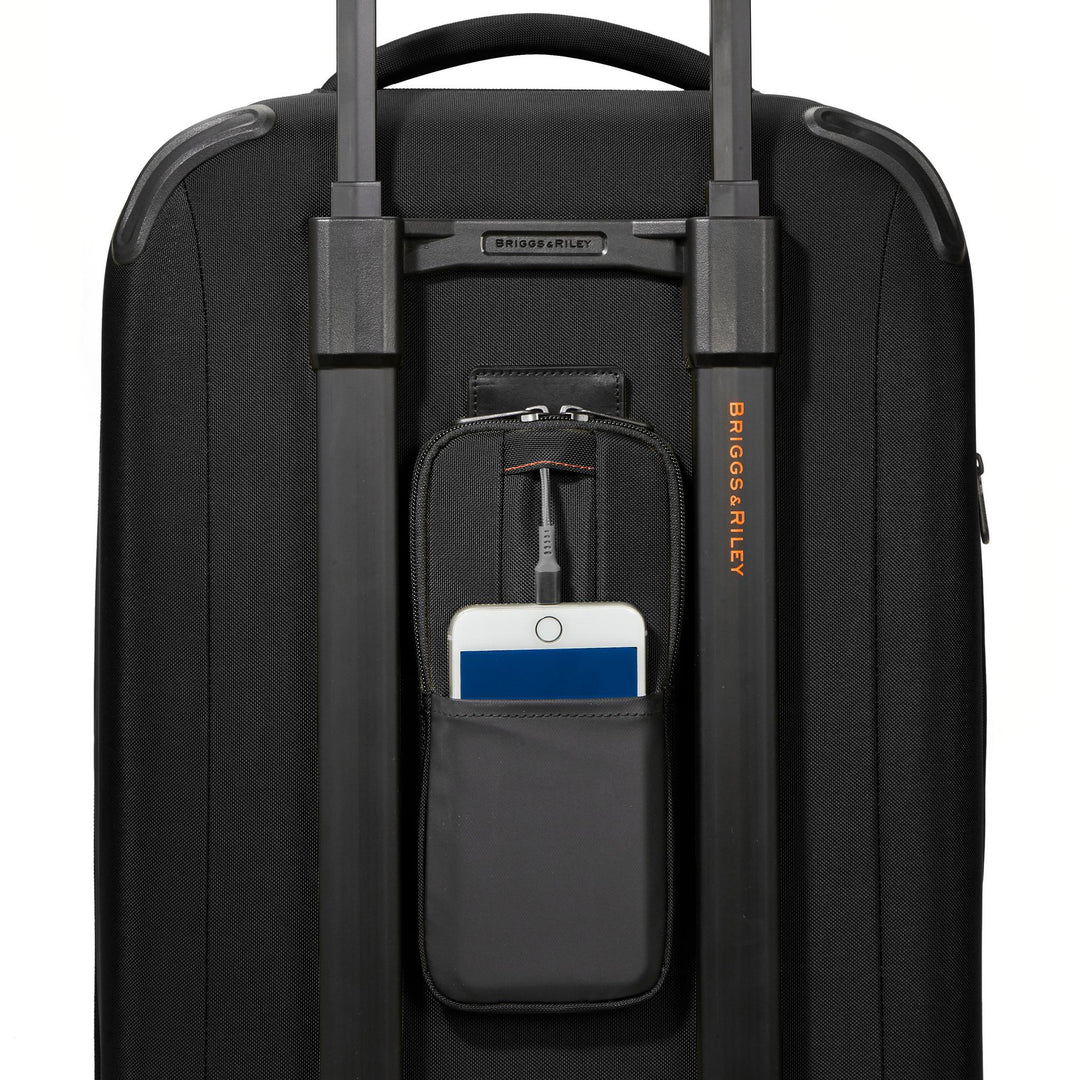 Briggs & Riley ZDX International 21" Carry-On Expandable Spinner showing close up of power pocket with power bank charging iphone