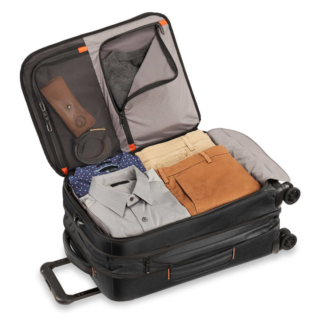 Briggs & Riley ZDX Domestic 22" Carry-On Expandable Spinner Inside is packed with pants, shirts, glasses, and belt