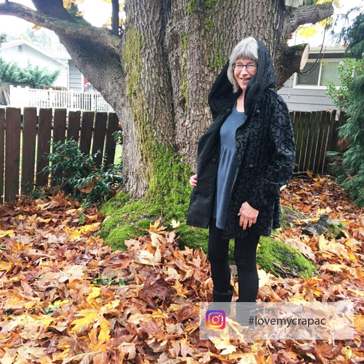 Cathy wears her Mycra Pac scroll coat outside in the fall leaves